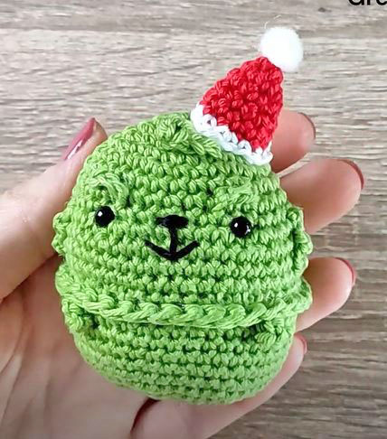chibi grinch crochet doll with a red christmas hat